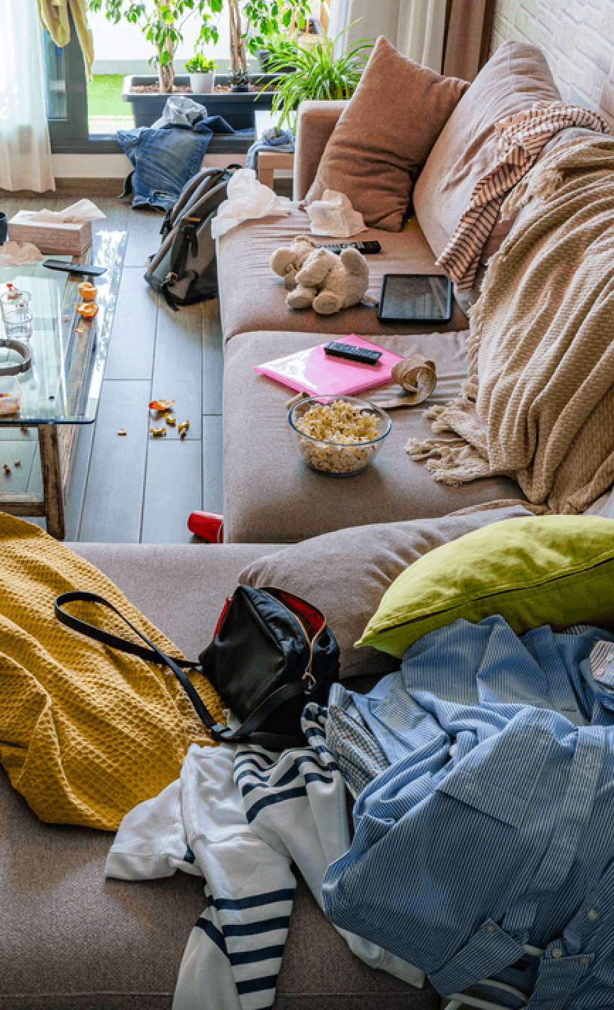 Een woonkamer waar de spullen van iedereen door elkaar liggen