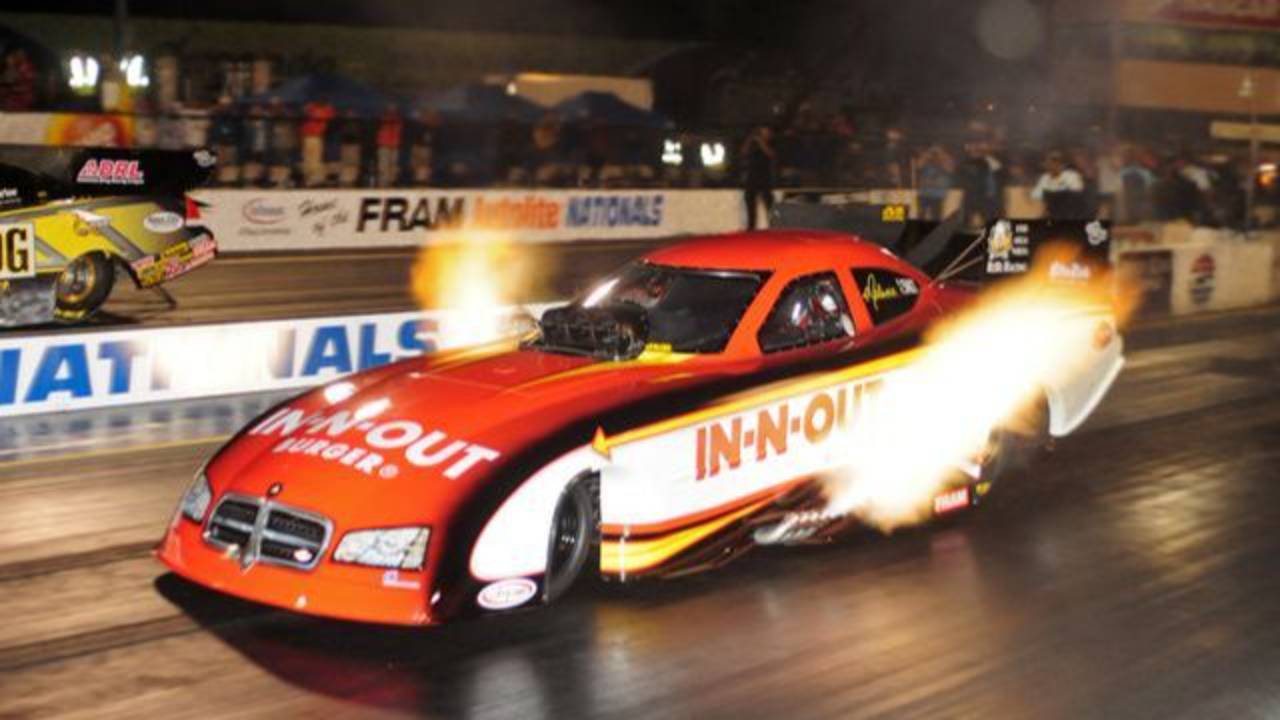 Funny car dragster launching with flames at the starting line