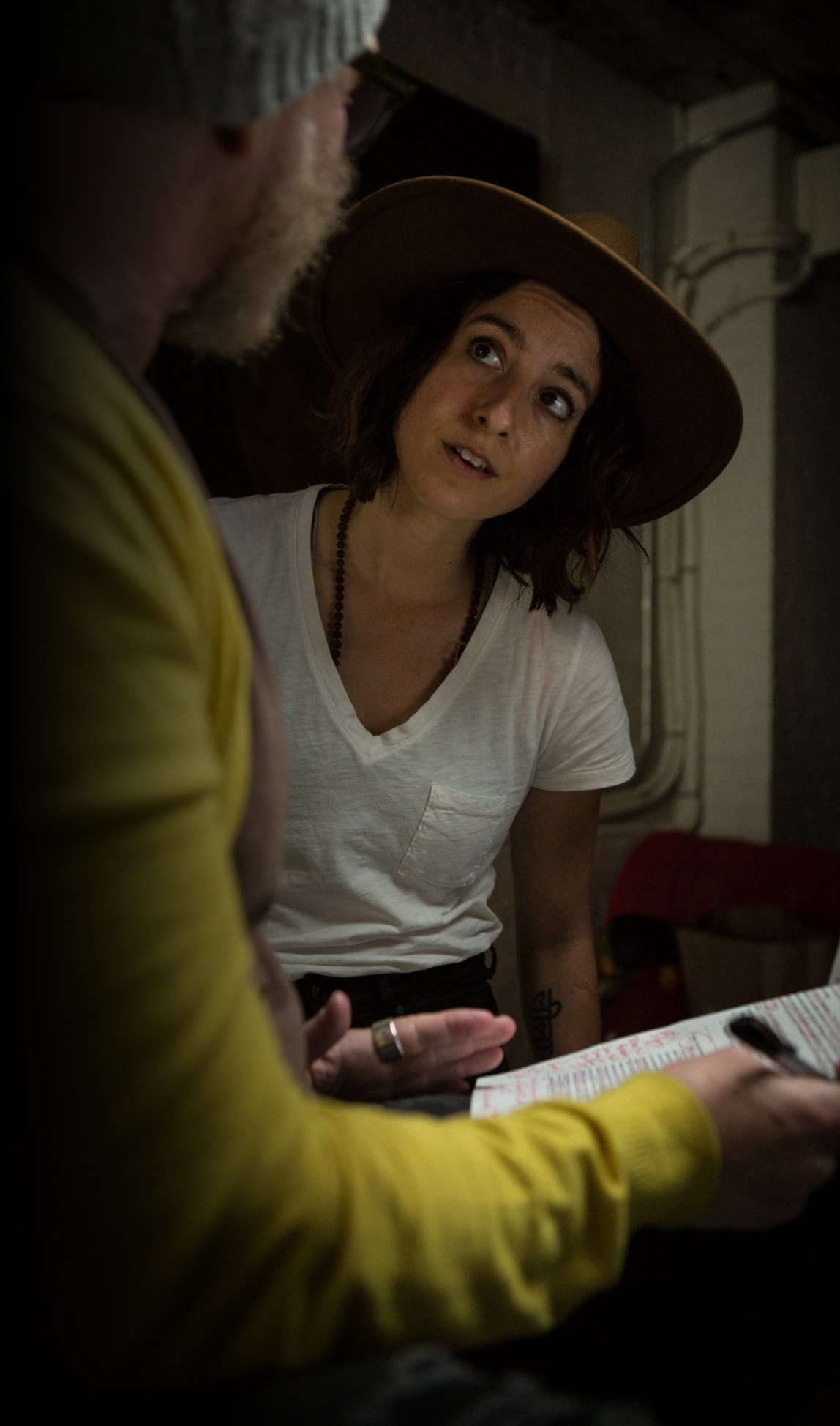 A woman in a white t-shirt looking off-camera, a script in the foreground