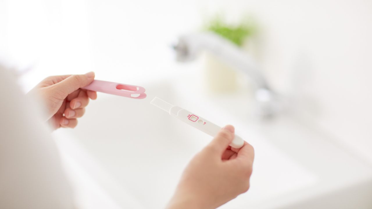 Woman holding a pregnancy test