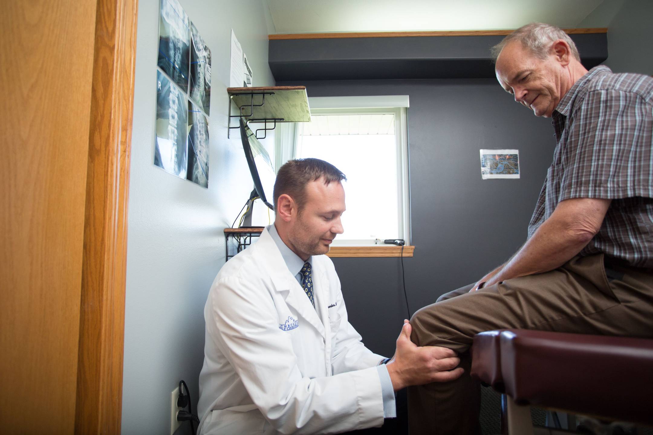 Chiropractor examining a patient's knee for regenerative medicine treatment