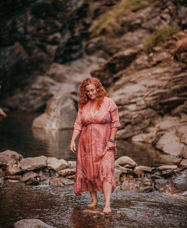 Michele Edwards walking barefoot through a mountain stream