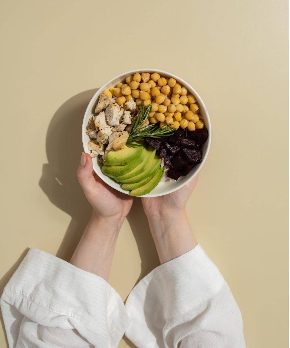 Hands holding a bowl of healthy food
