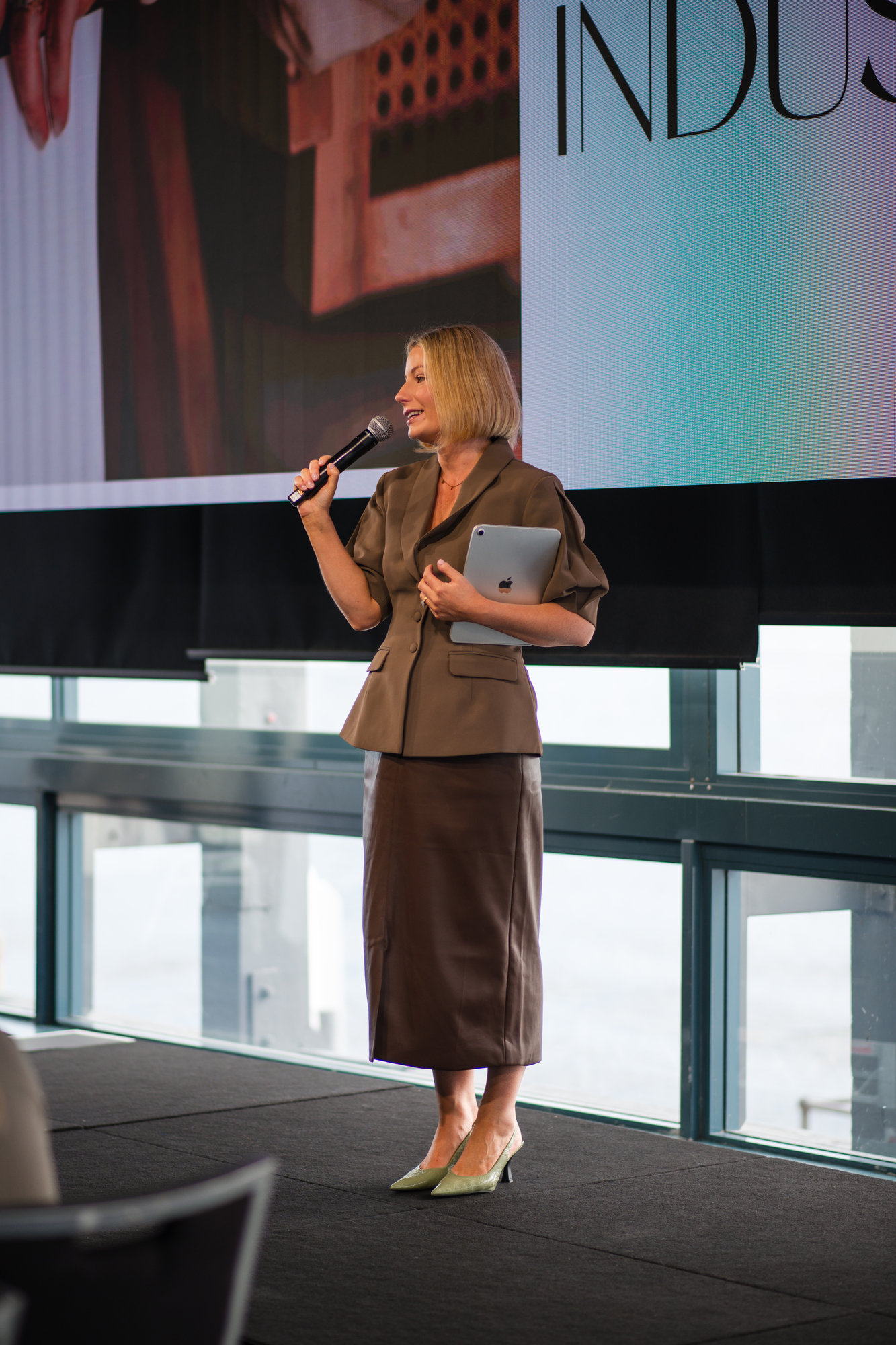 Tamara Reid speaking on stage with a microphone