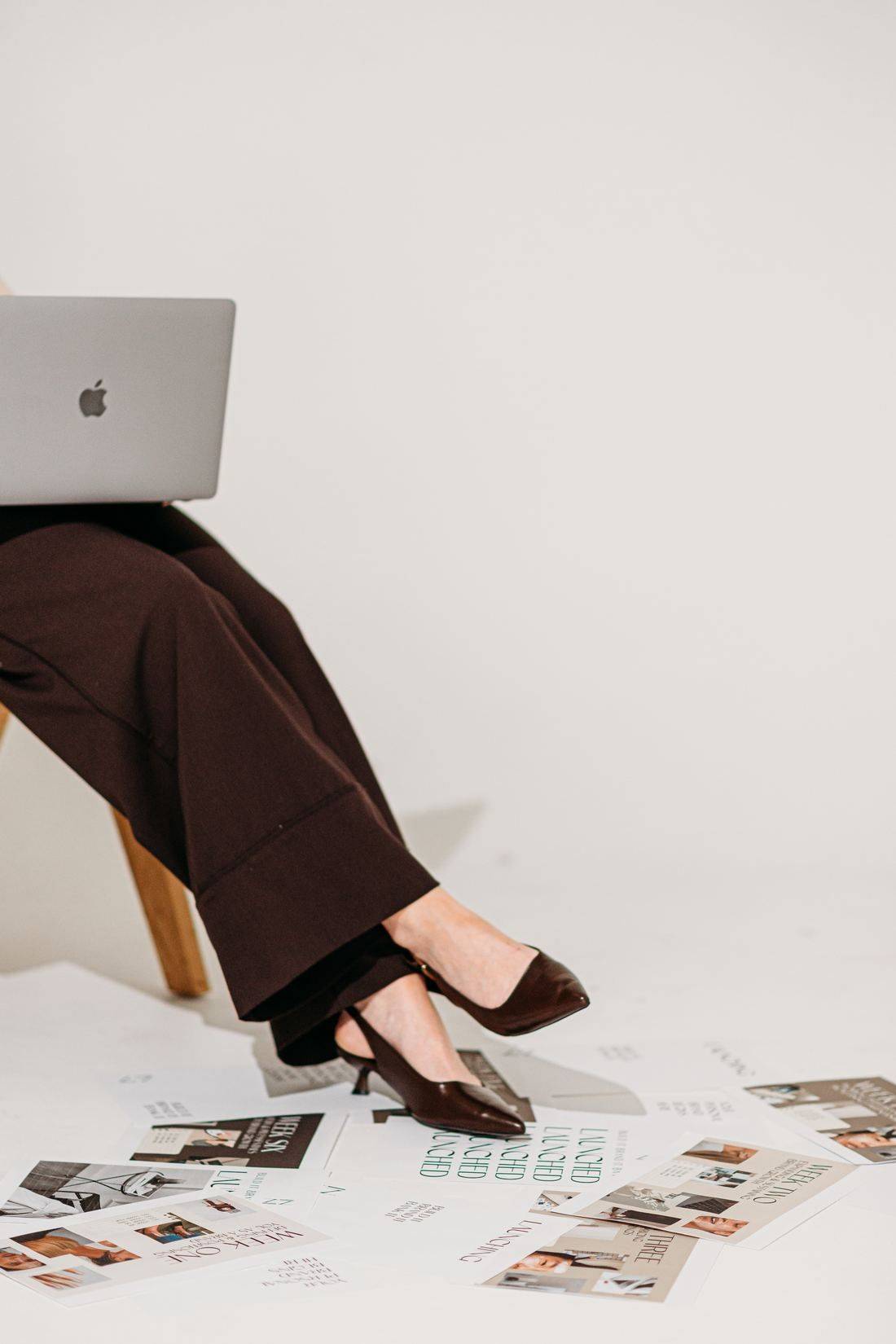 Tamara with her laptop and personal brand planning pages spread across the floor