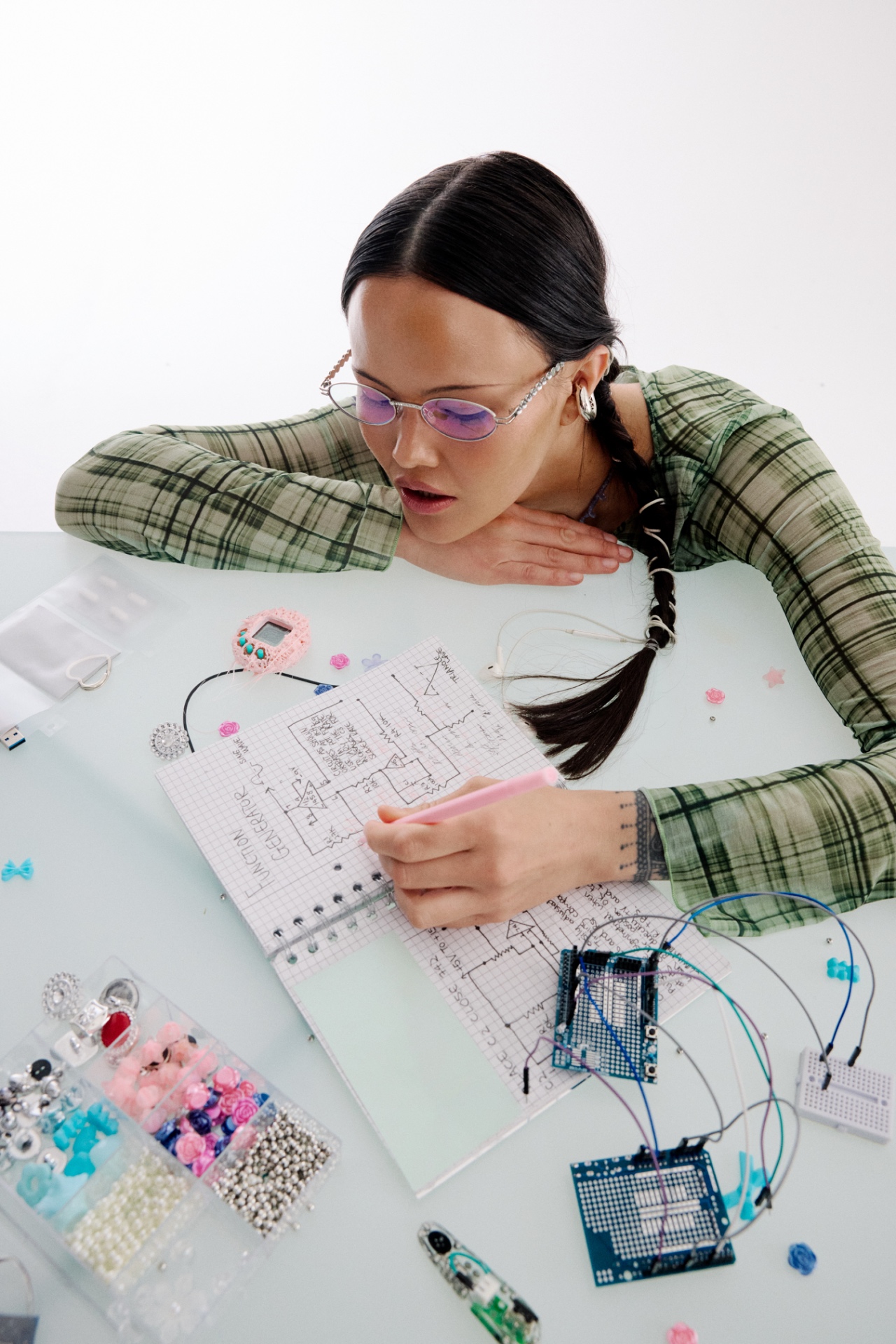 An educator resting her chin on her arm while sketching notes at her desk