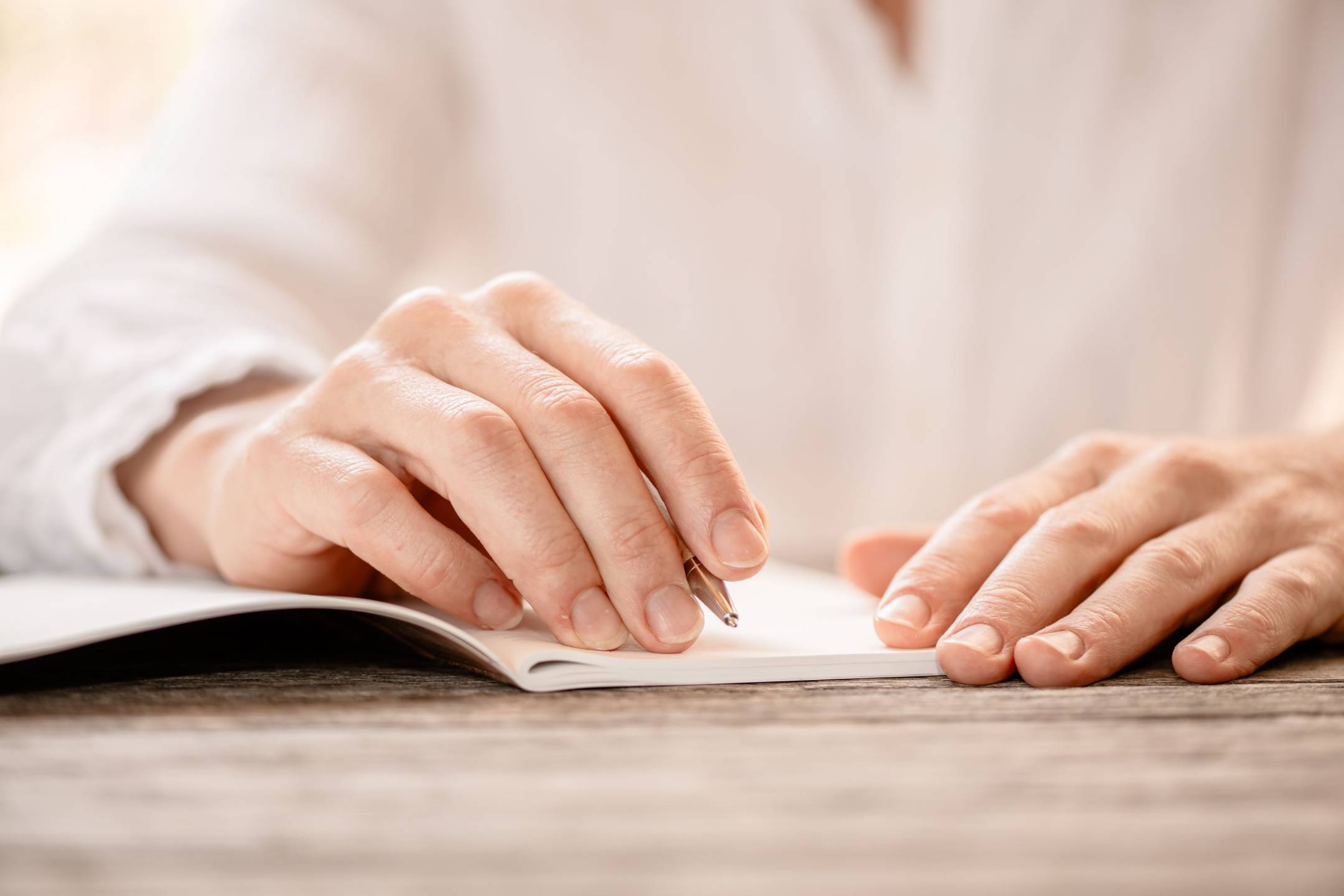 Hands writing in a notebook โ a quiet moment for yourself