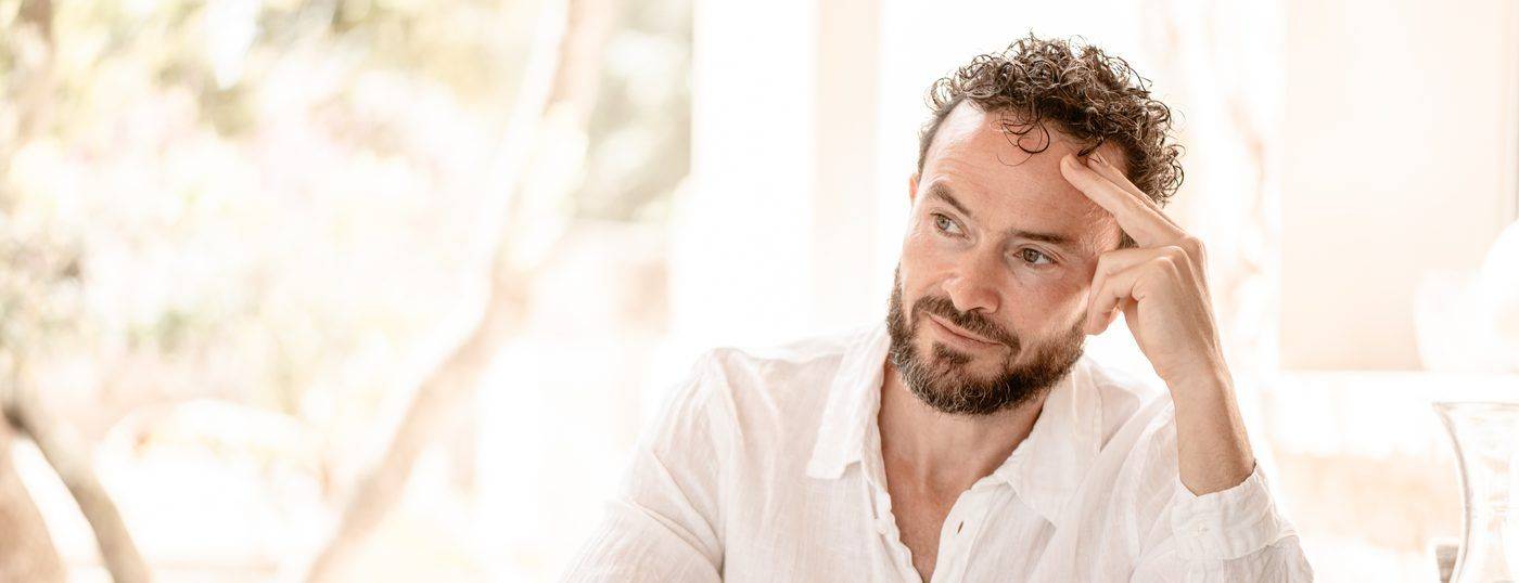 A man sitting at a table with eyes closed, in quiet focus