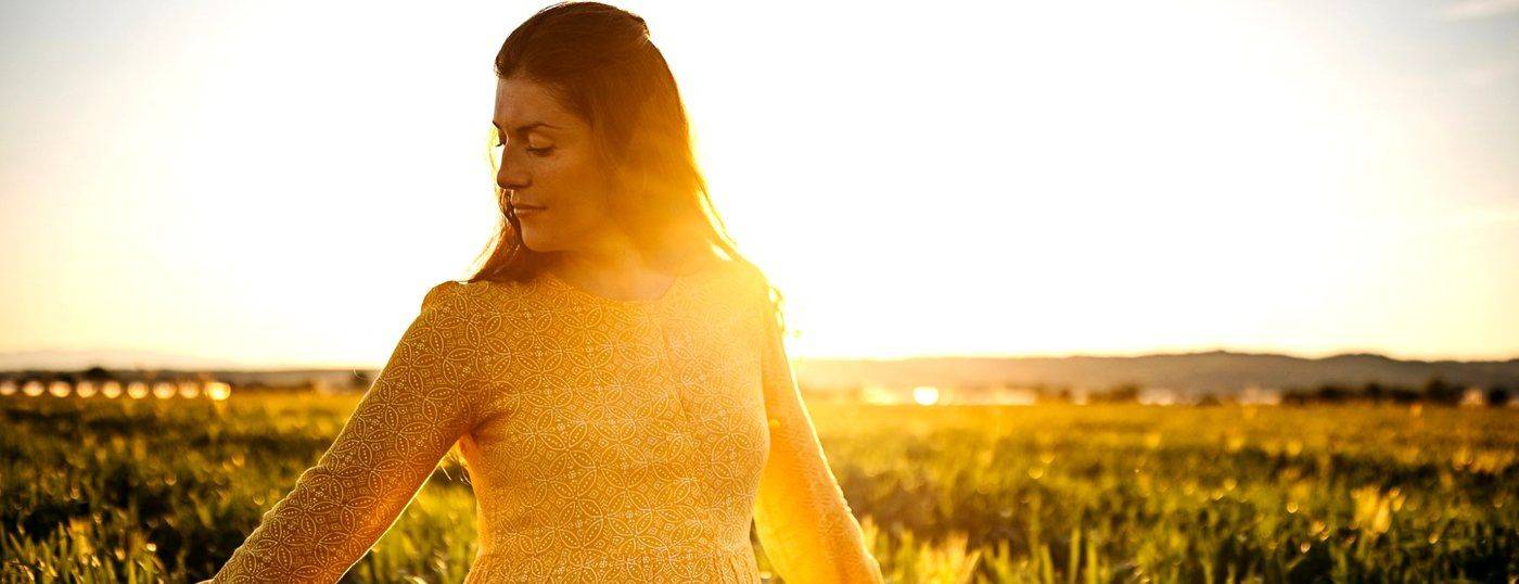 A woman walking through a sunlit field