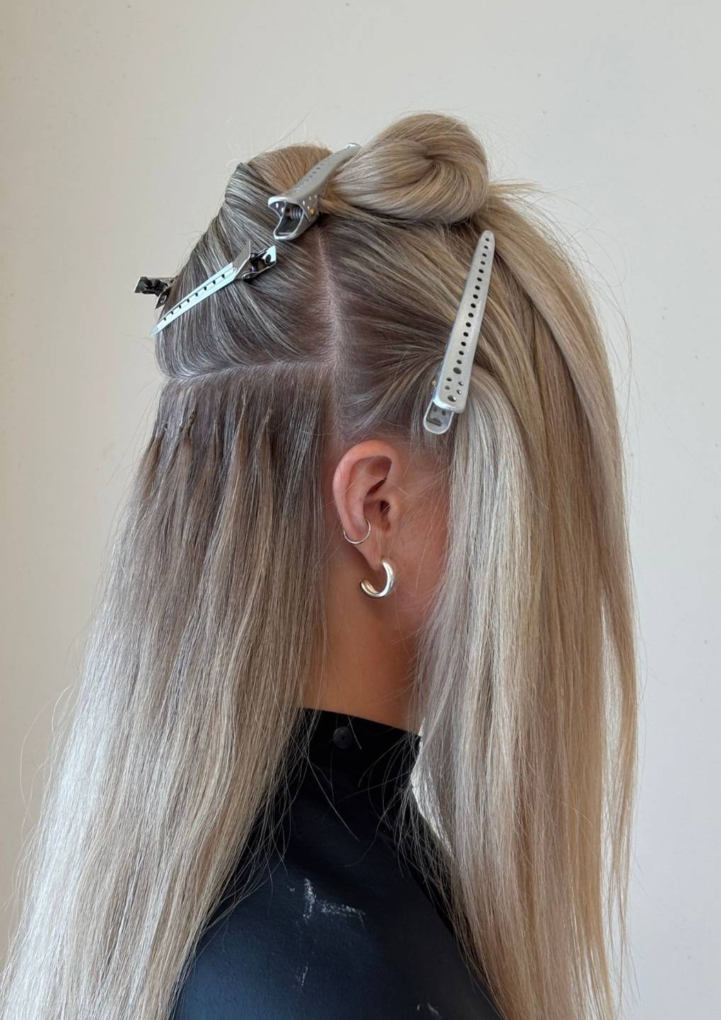 Blonde keratin bond hair extensions showing precise sectioning and discreet bond placement