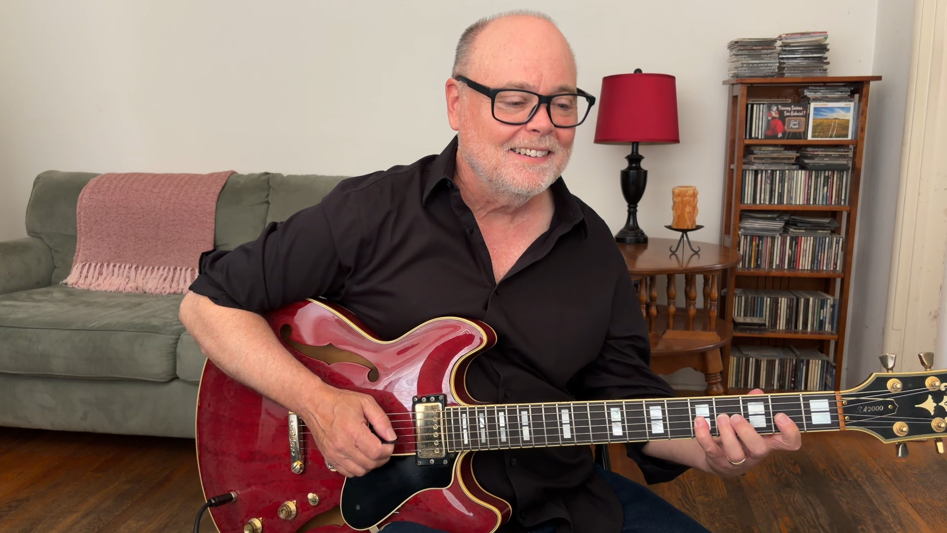 Adult guitarist practicing jazz guitar in a warm lesson-room or studio setting