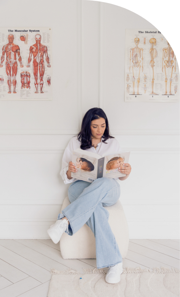 Dr. Thea Zacharia reading a wellness book in a chiropractic clinic