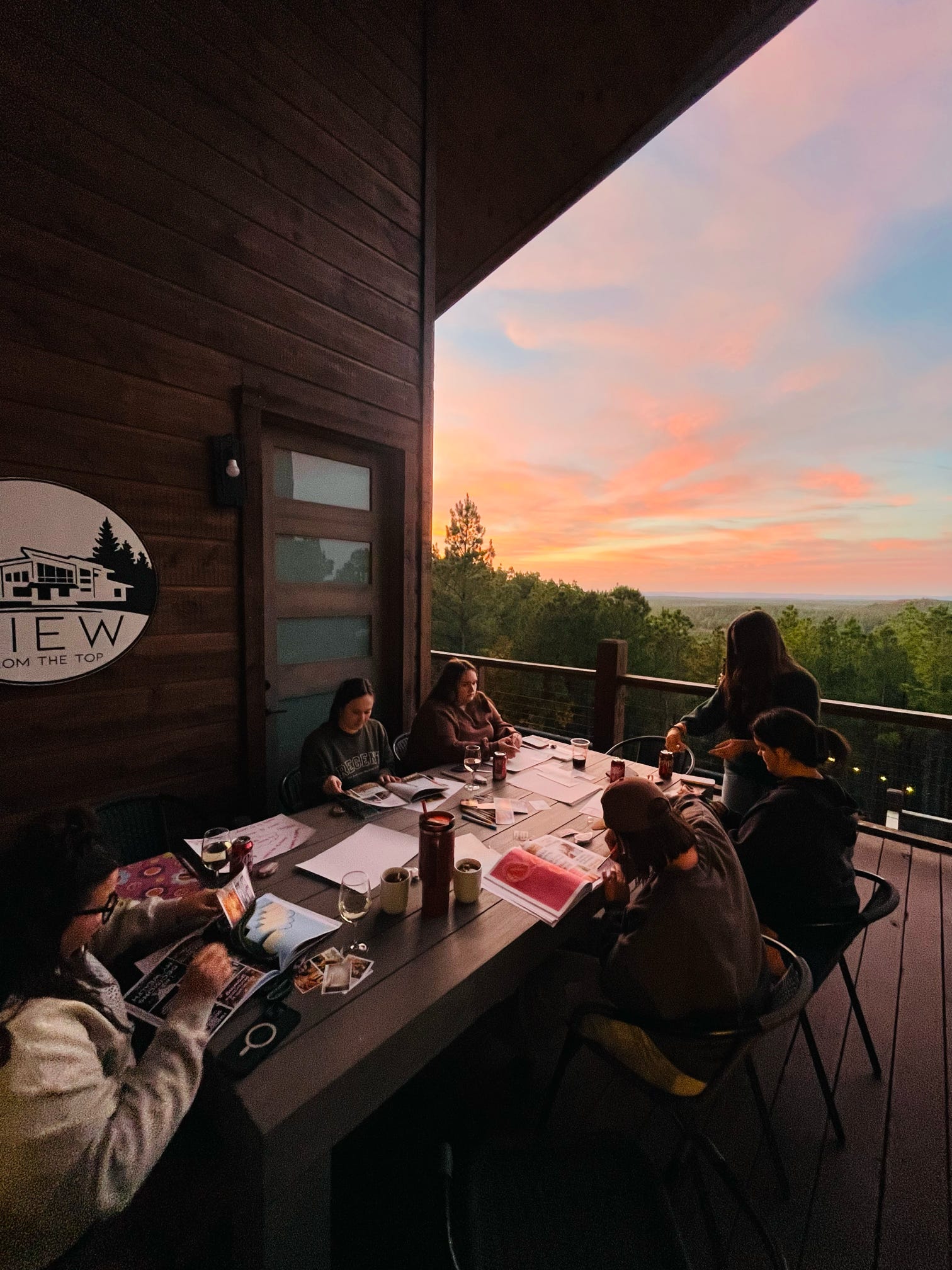 Women gathered at the deck table at sunset