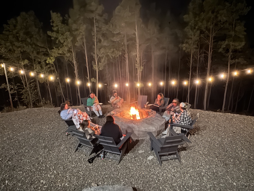 Women gathered around a firepit at night