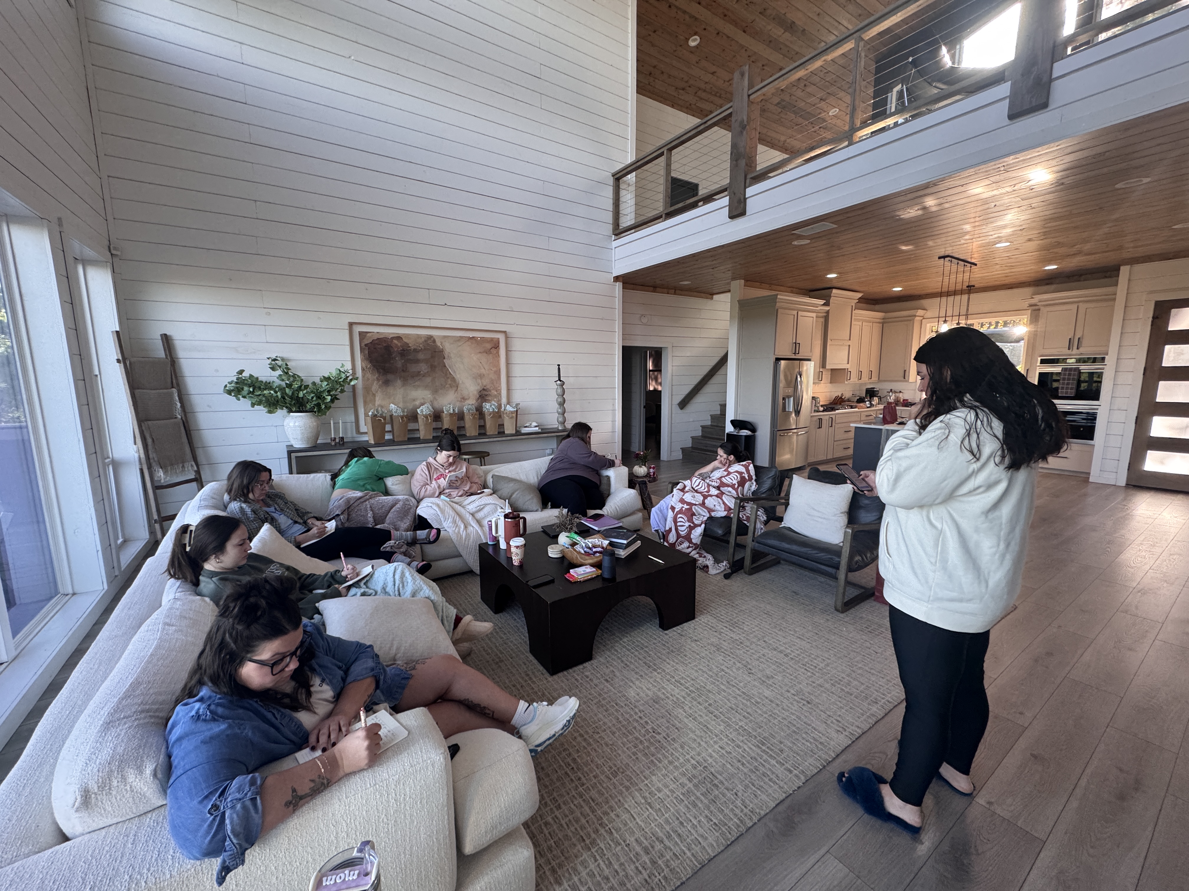 Women journaling together in the living room