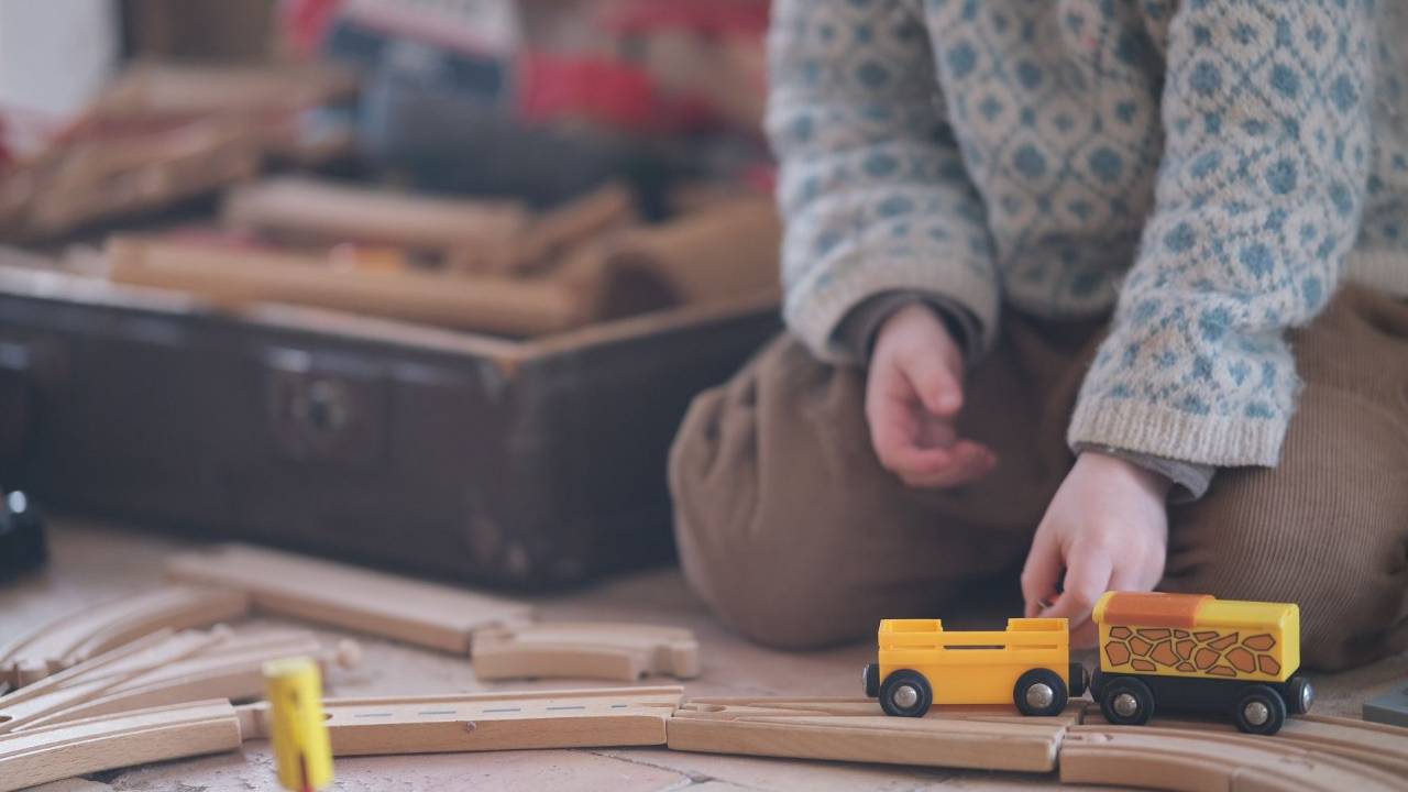 A child playing with a wooden train set