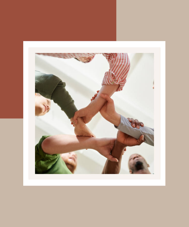 A diverse group of people joining hands in a circle to symbolise teamwork, unity and connection, presented in a white frame against a terracotta and beige background.