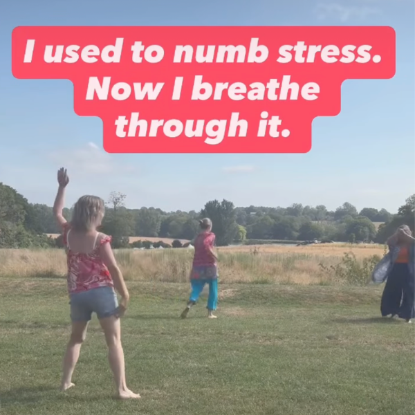 Three women moving freely in a grassy field during an outdoor breathwork session, with the text “I used to numb stress. Now I breathe through it.” displayed above them.
