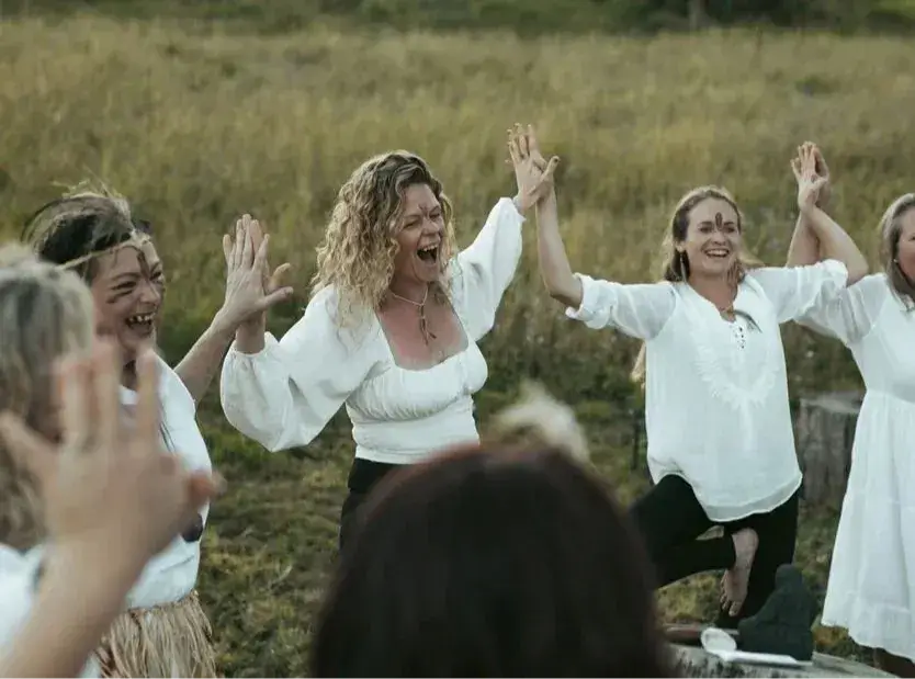 Women dancing together outdoors during a retreat circle
