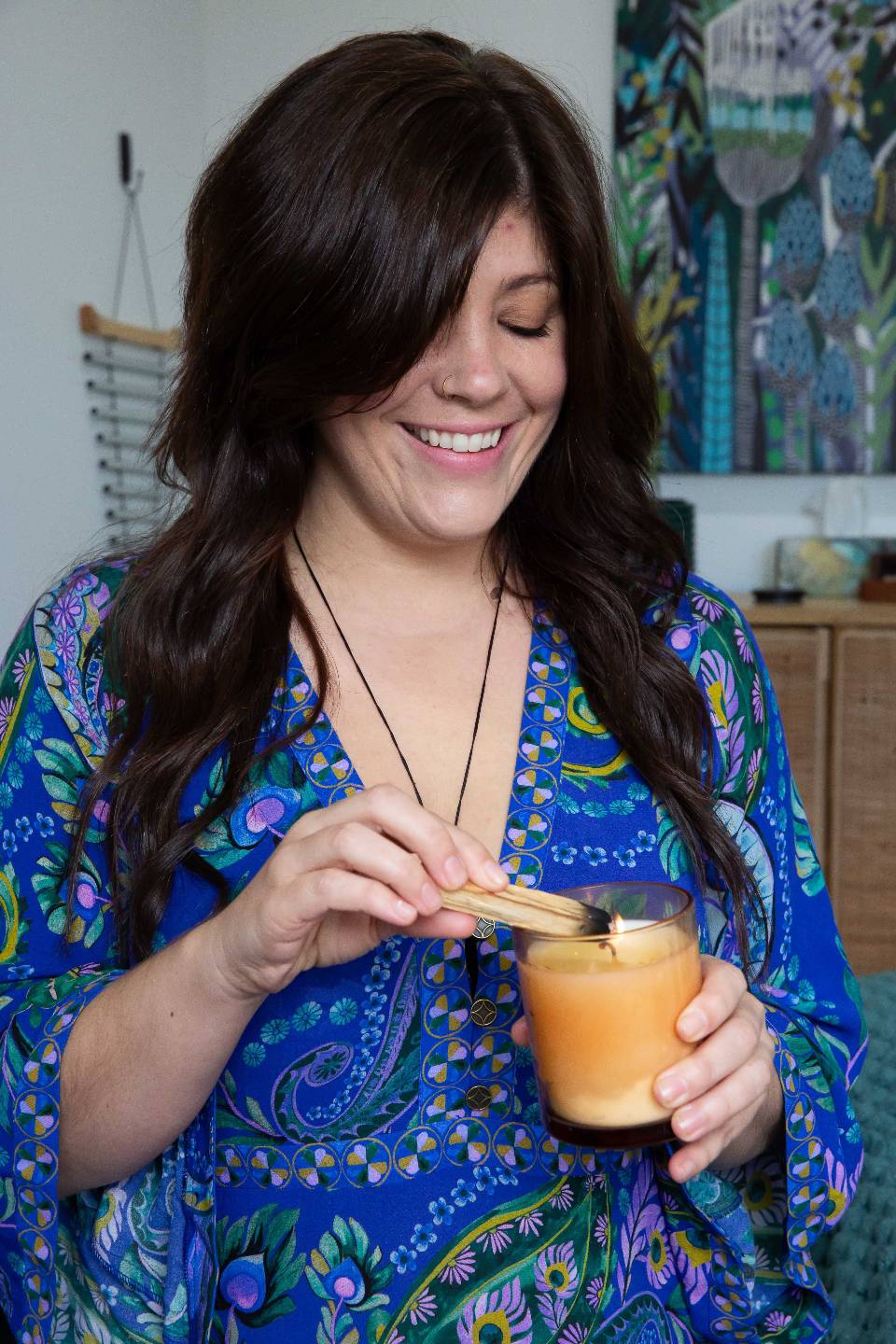 Bailey Womack lighting palo santo from a candle