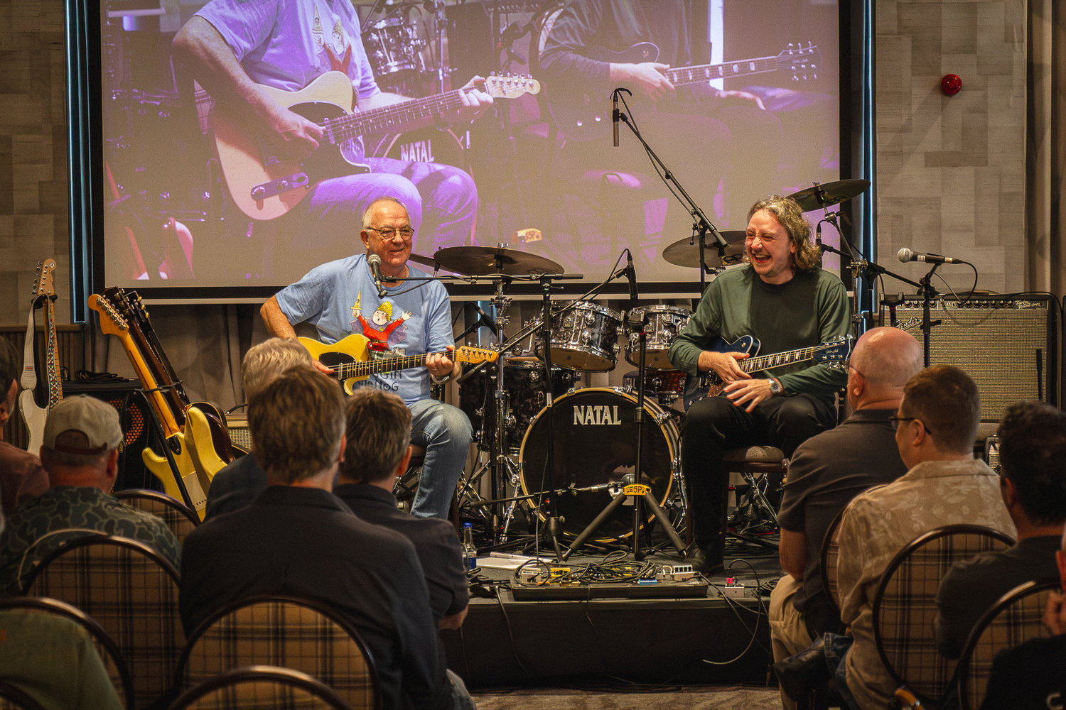 Two guitarists playing together on stage during a jam session