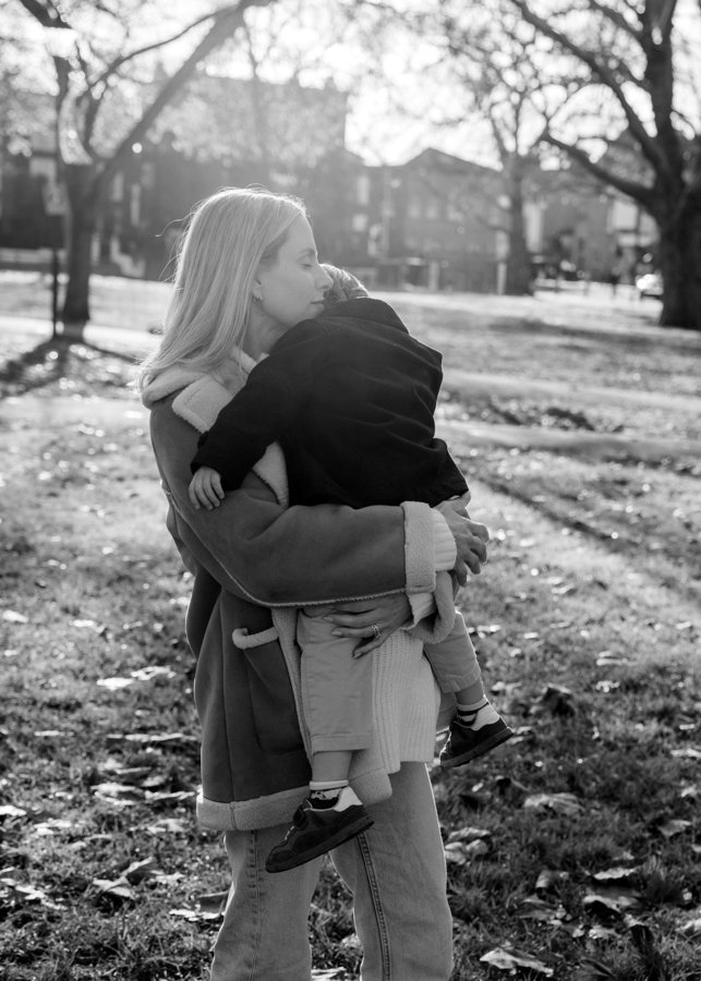 Carmela carrying her toddler in the park