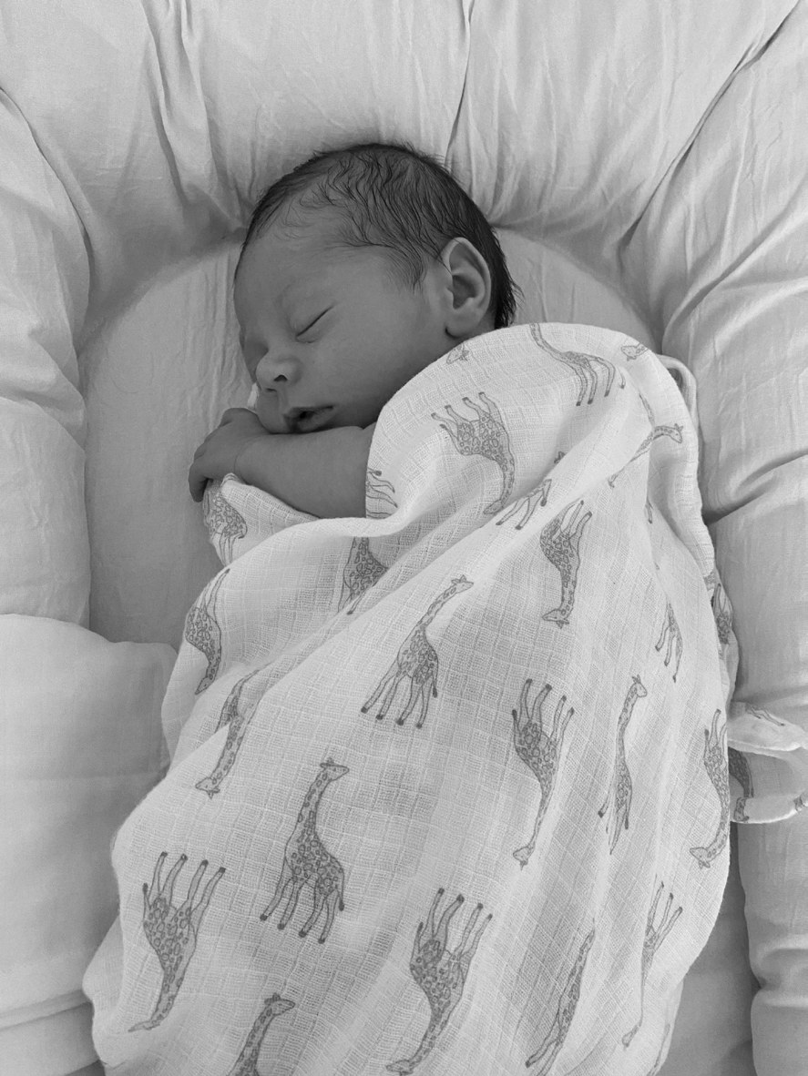 Newborn baby asleep, swaddled