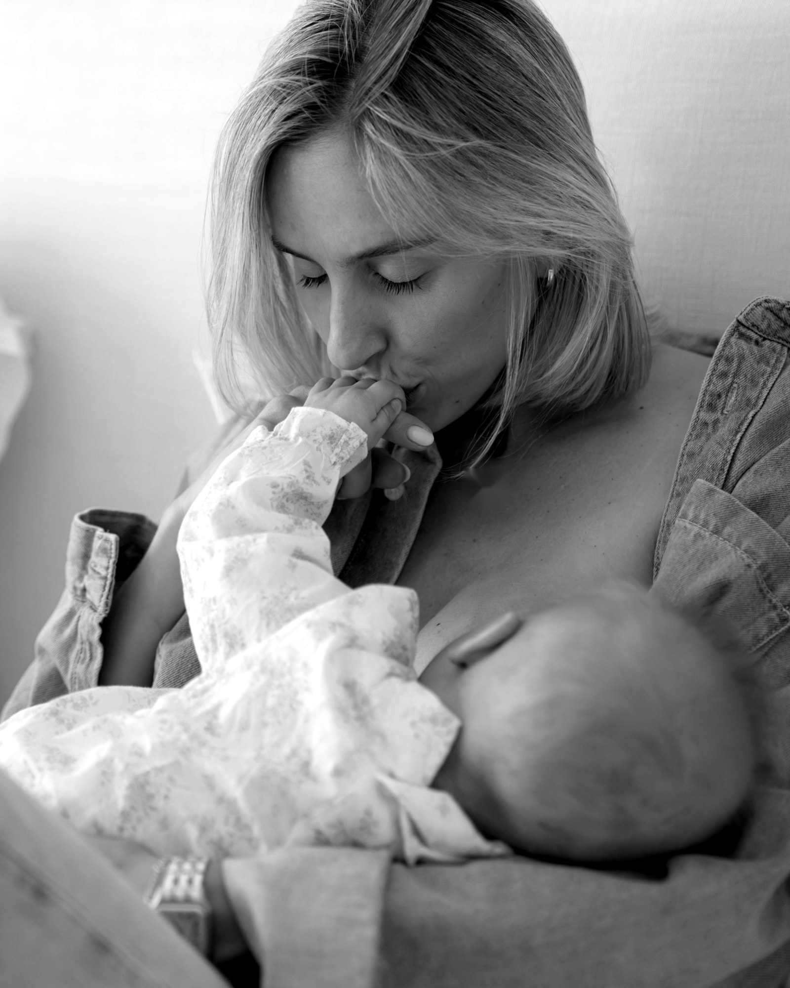 Carmela kissing her baby's hand while breastfeeding