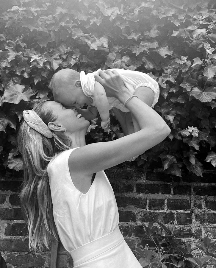 Carmela lifting her baby in the garden