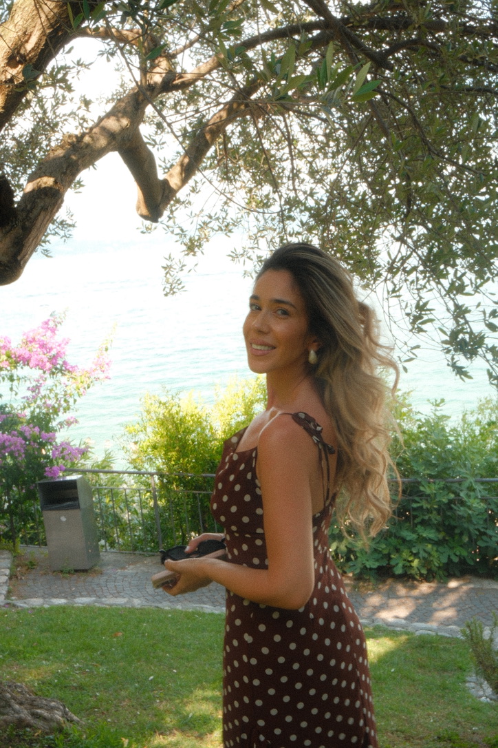 Flavia zâmbind, sub un măslin, lângă mare