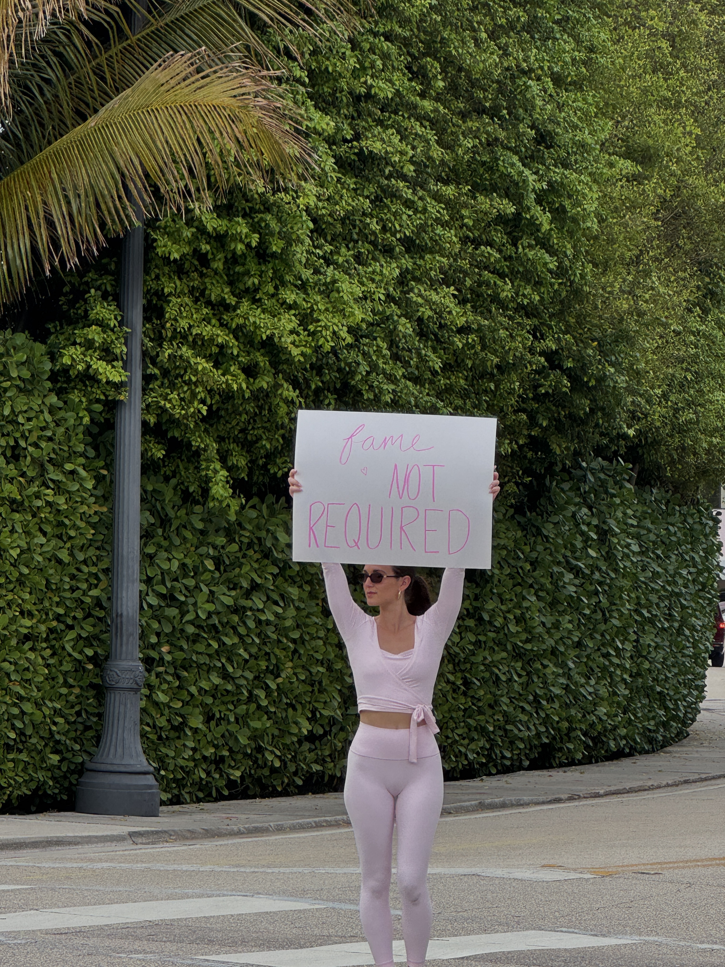 Mackenzie holding a Fame Not Required sign