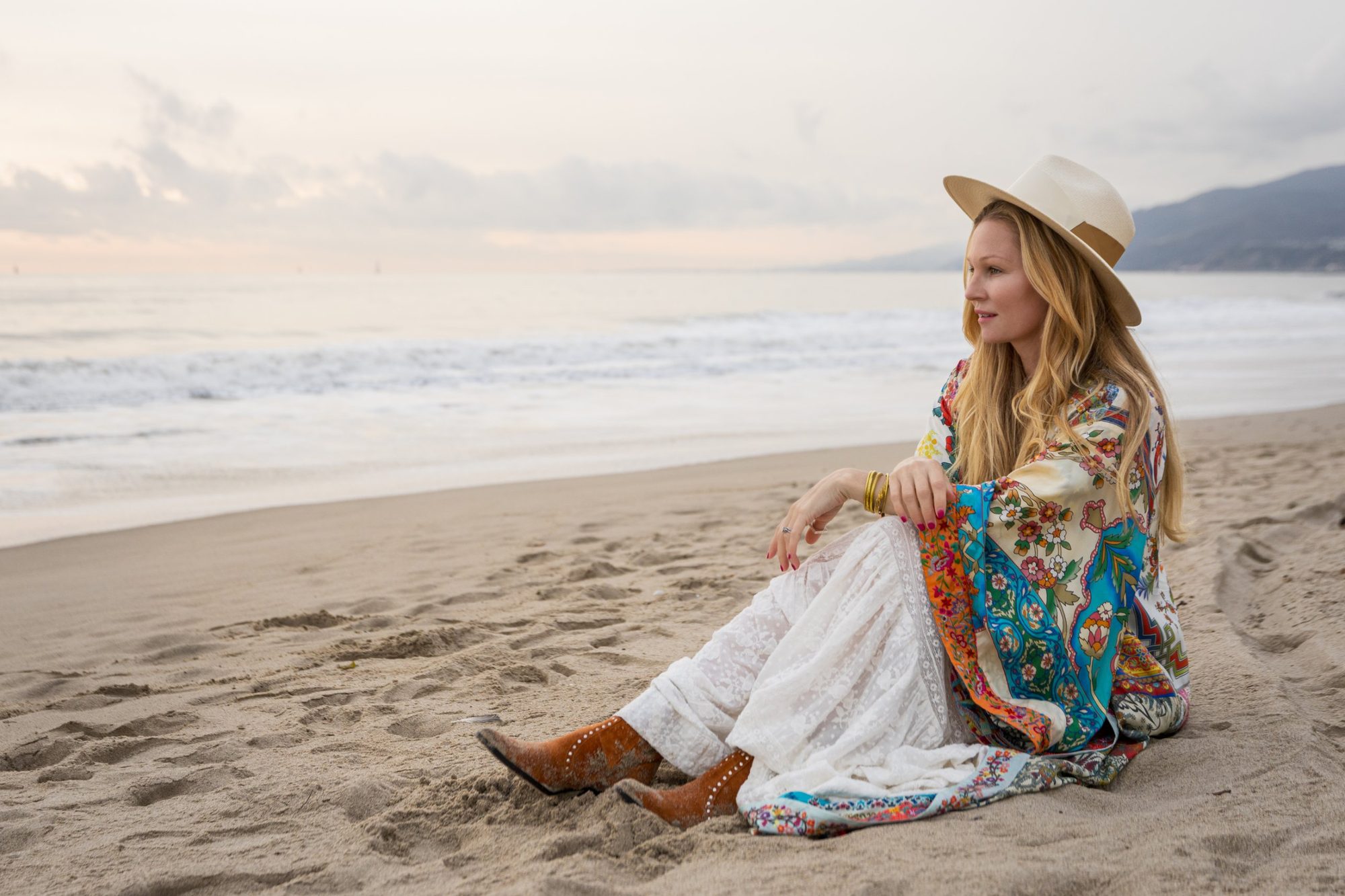 Emma Owen sitting on the beach at sunrise