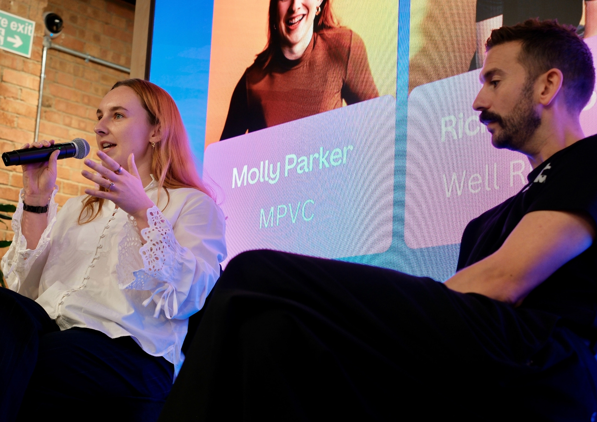 Molly speaking on a panel with a microphone