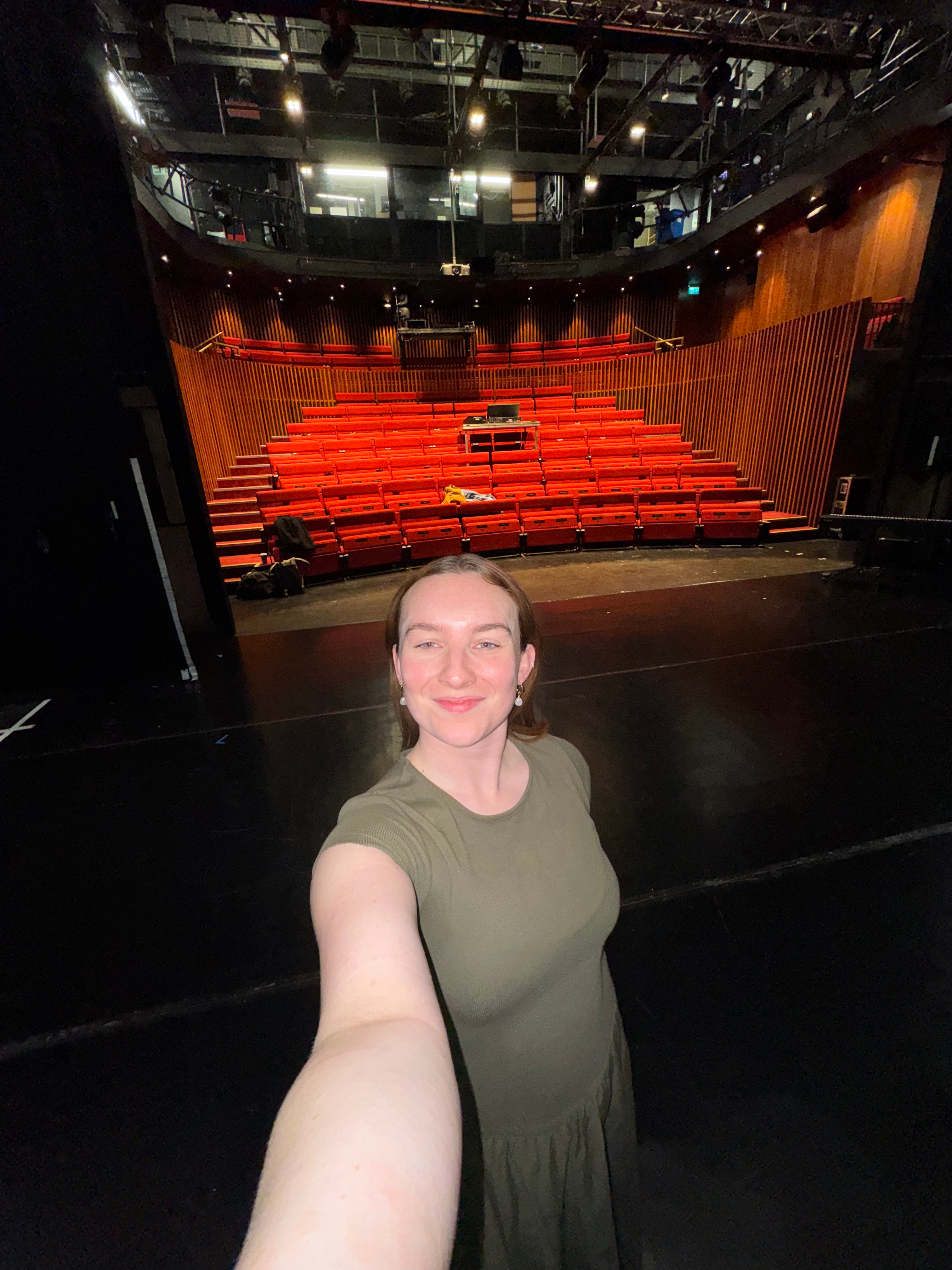 Molly taking a selfie on an empty theatre stage