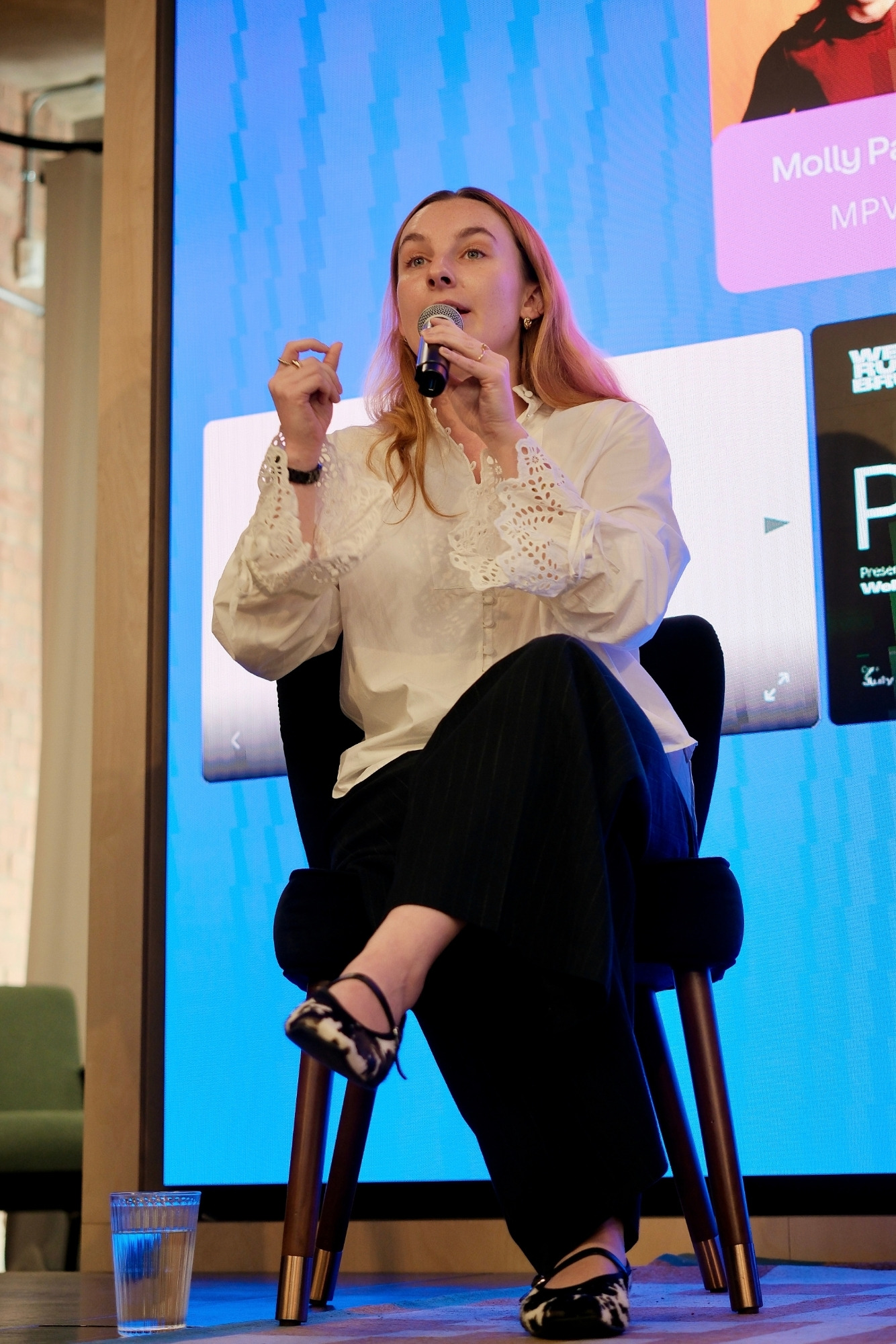 Molly speaking on stage with a microphone