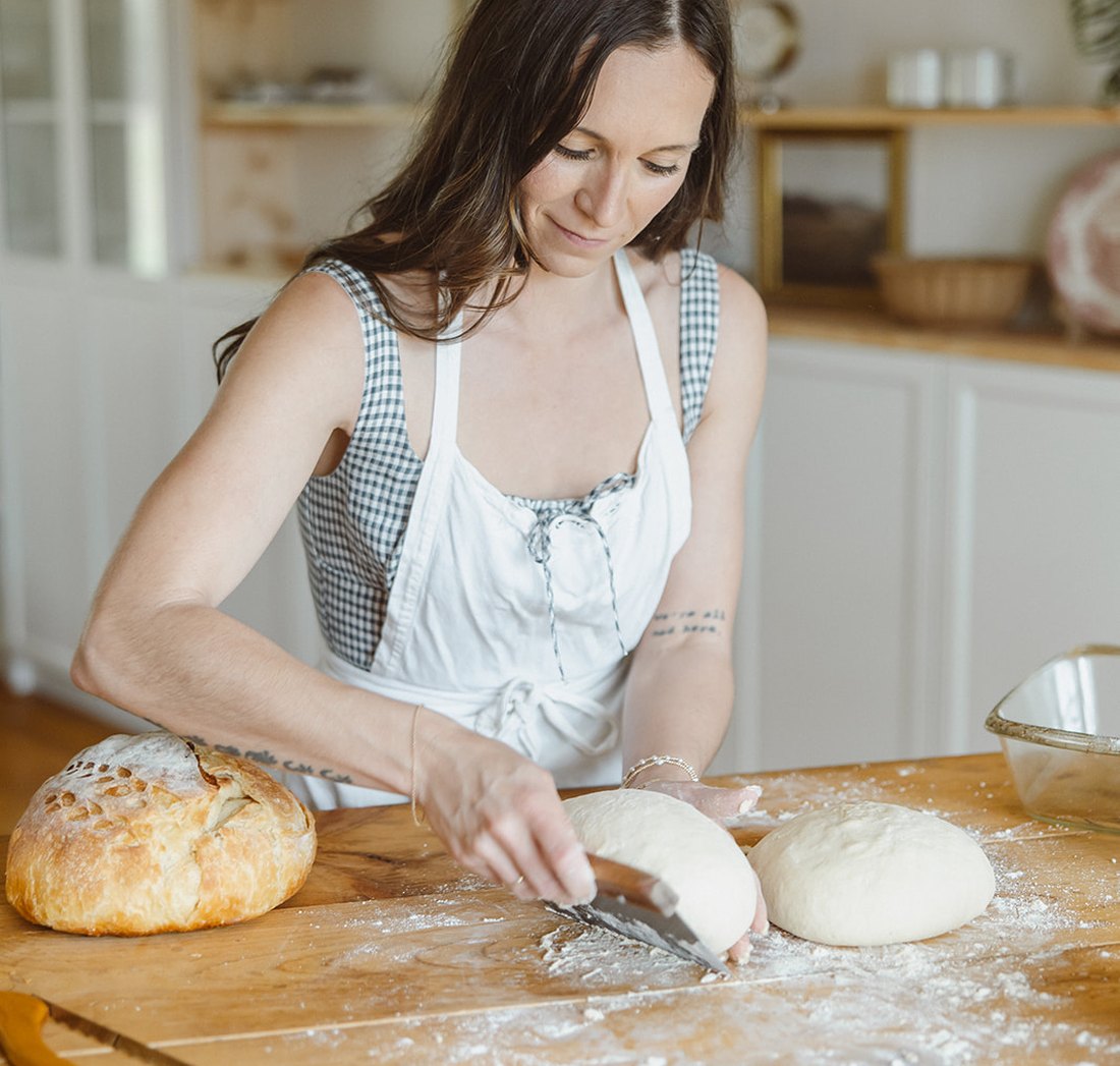 Selina slicing homemade bread in her kitchen