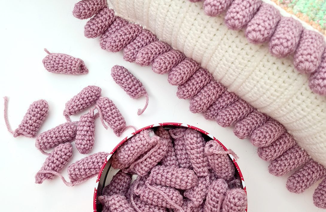 Dozens of small crocheted tentacle pieces waiting to be assembled