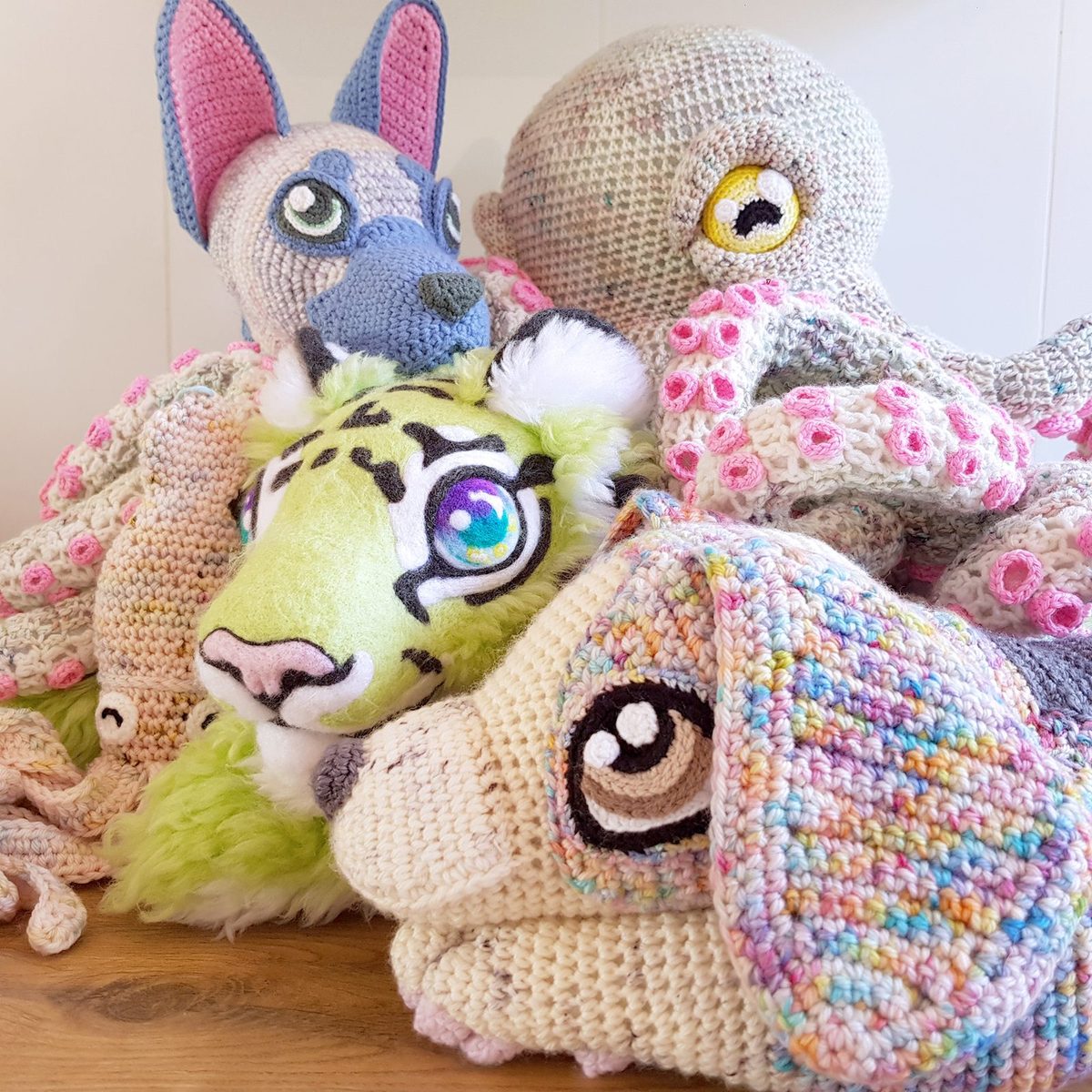 A cosy pile of Jessie's crocheted creatures including a tiger, a dog and a dragon