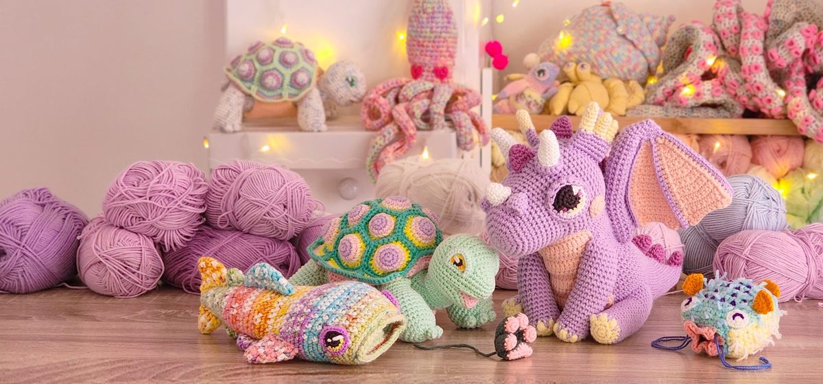 Balls of yarn beside crocheted creatures in Jessie's studio