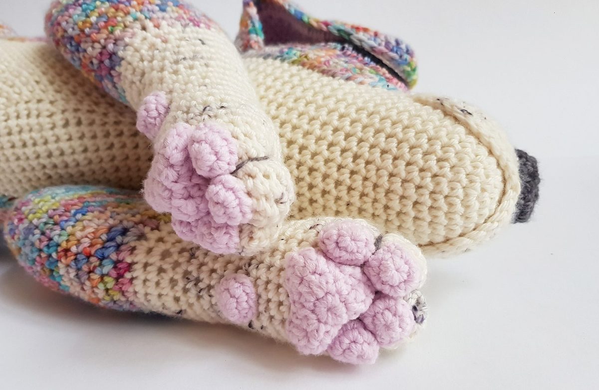 Close-up of crocheted creature feet and legs