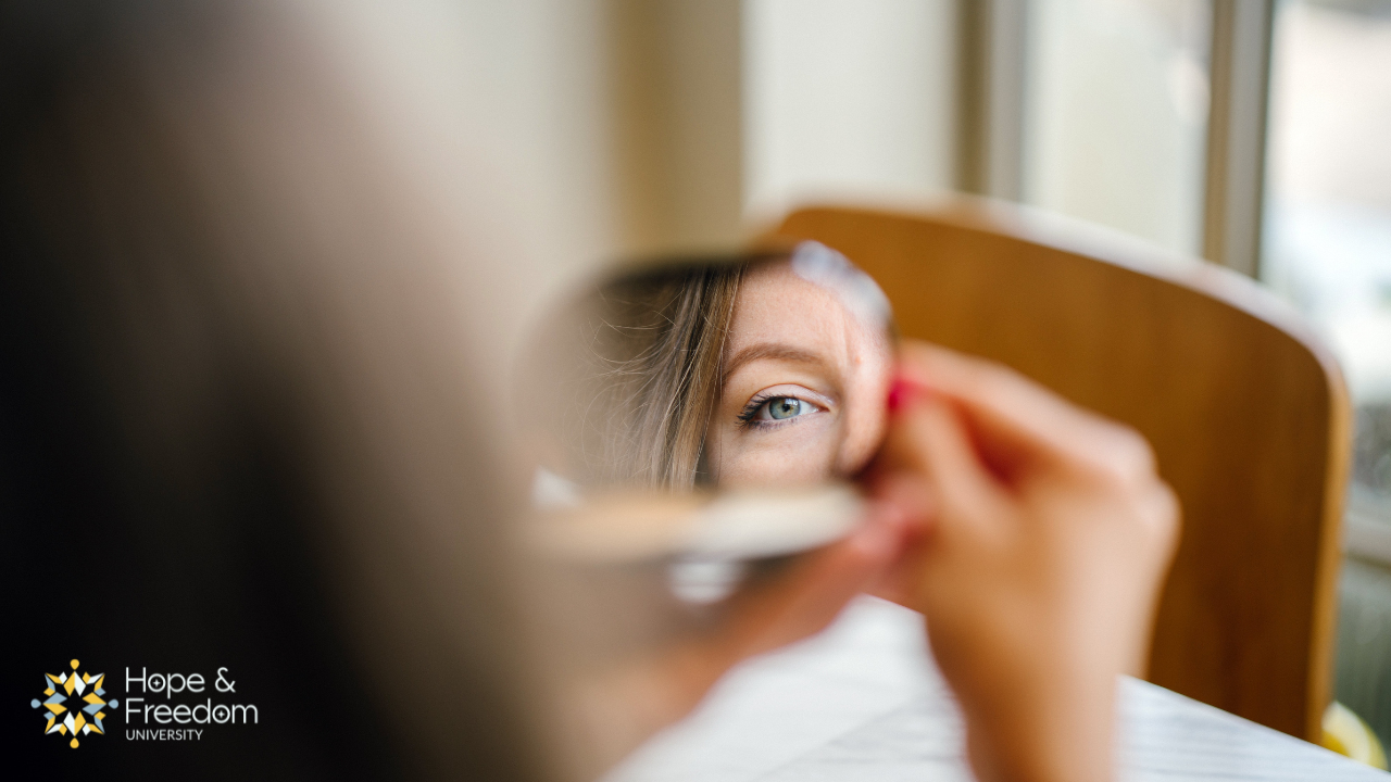 woman looking in mirror questioning identity after betrayal