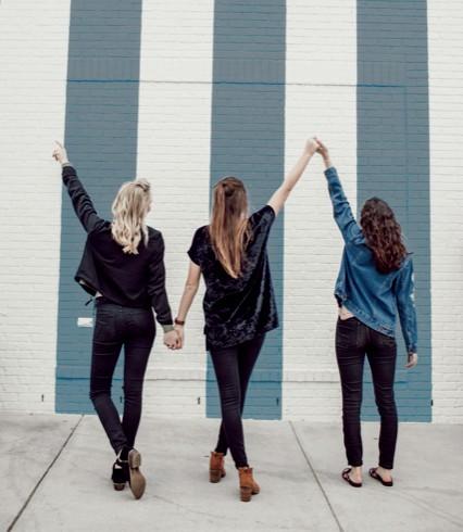 Three successful home stagers holding hands celebrating
