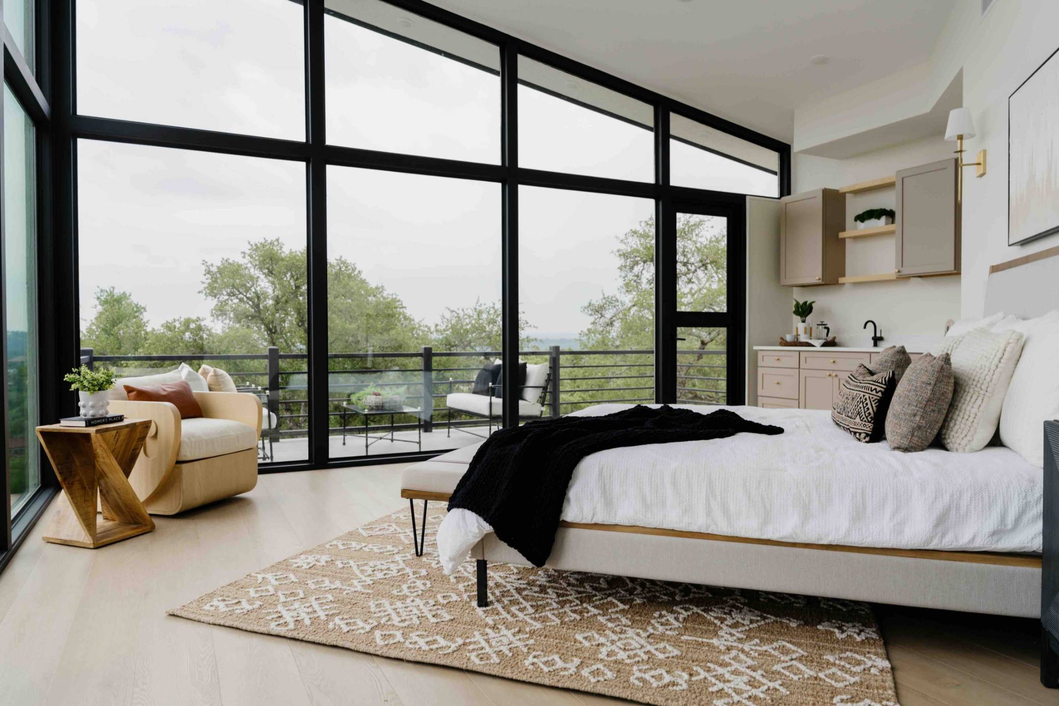 Professionally staged modern bedroom with large windows and contemporary furnishings