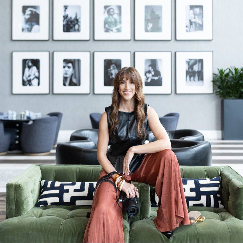 Vanessa Joy, wedding photography business coach, sitting with her camera in a hotel lounge