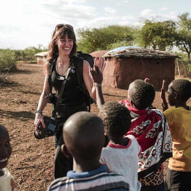 Vanessa Joy high-fiving children during a photography trip in Kenya