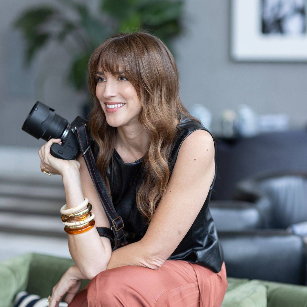 Vanessa Joy, wedding photography business coach, smiling while holding her camera