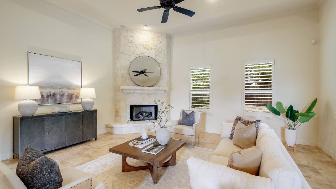 Bright living room with neutral seating and a stone fireplace.