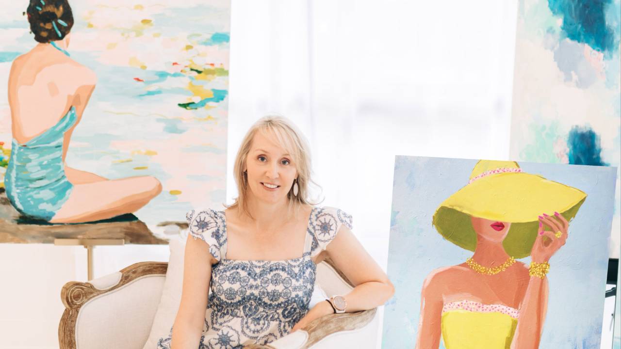 Artist Kristin Cooney with colorful artwork from her growing online art business.