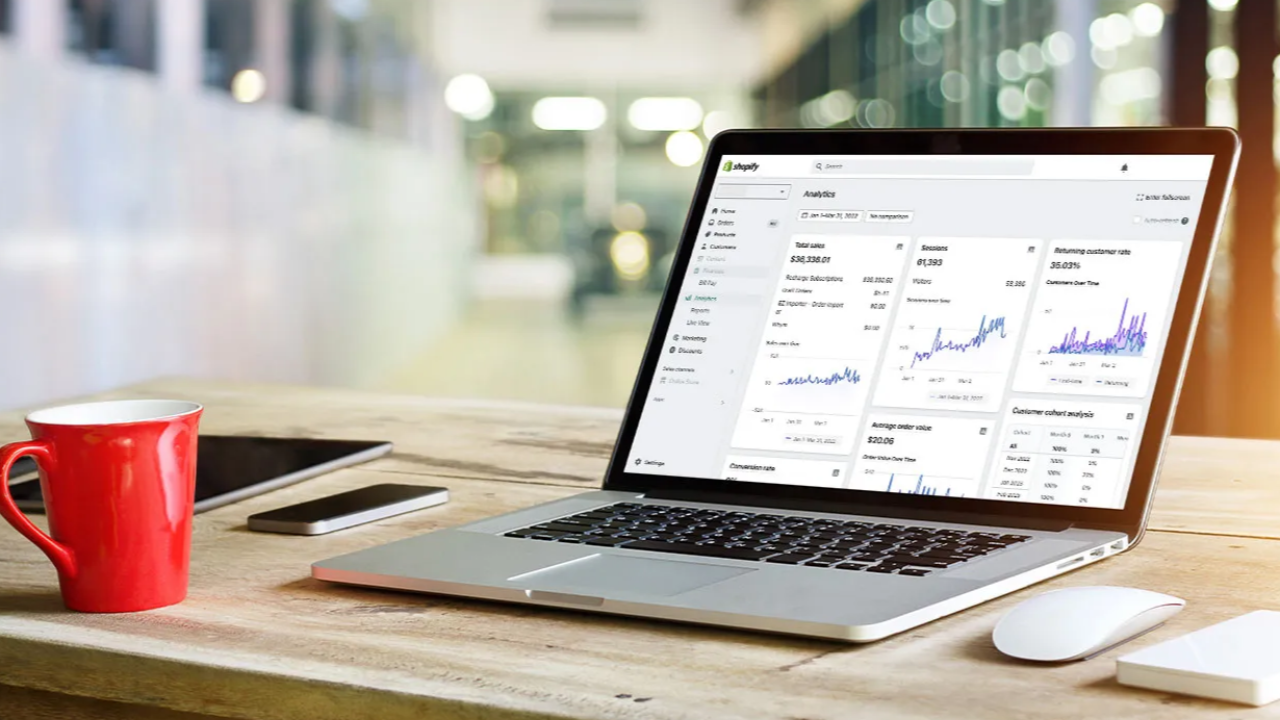 Shopify analytics dashboard showing ecommerce sales, traffic, and conversion metrics on a laptop computer.