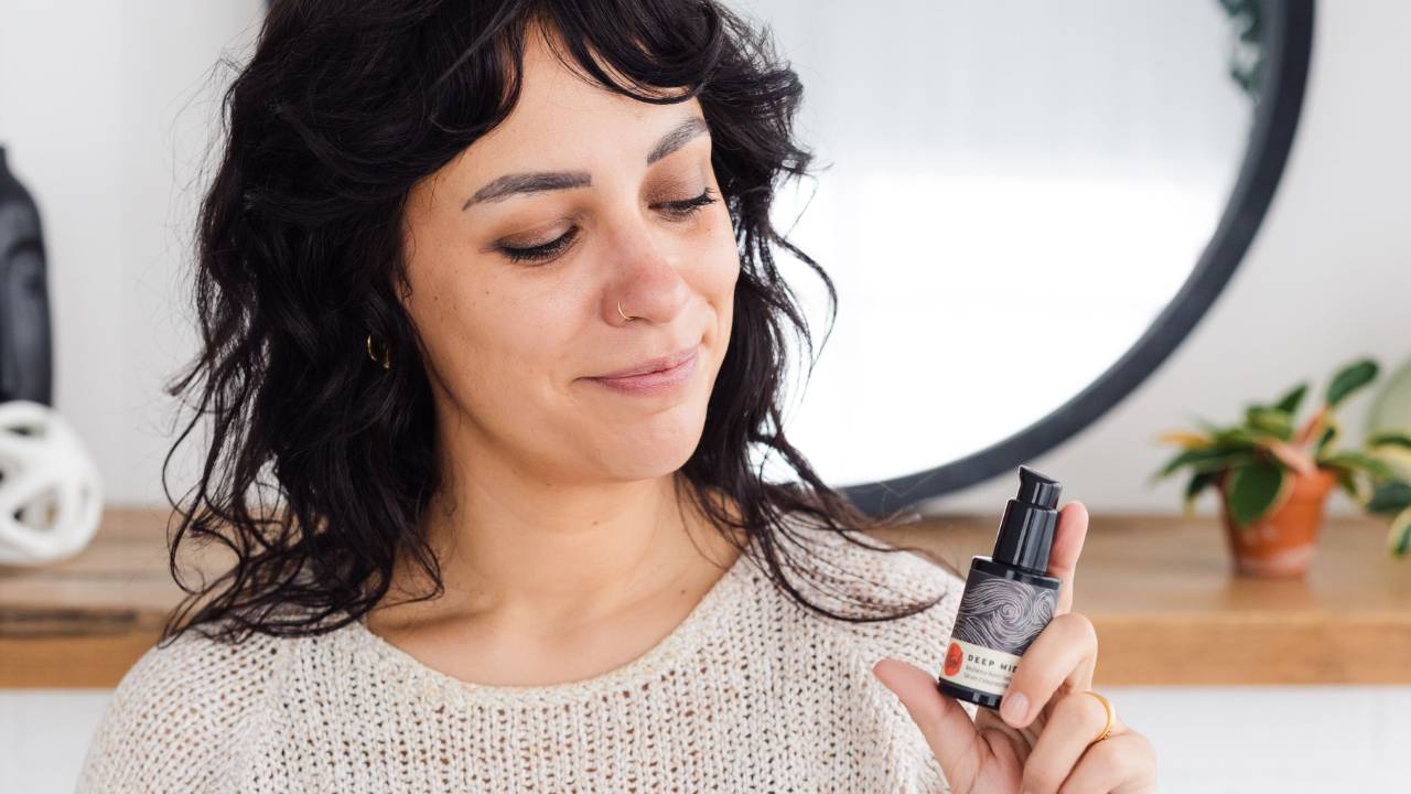 Jessica Lafleur, founder of ecommerce skincare brand Stark Skincare, holding a facial skincare product
